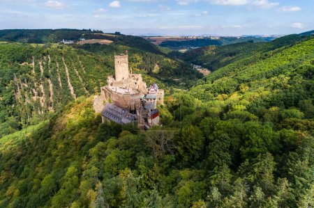 Photo for Aerial view rock with medieval castle Ehrenburg on it near moselle river in Brodenbach with forest hills. - Royalty Free Image