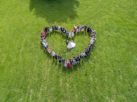 Photo for Wedding guests lined up in the shape of heart with bride and groom marriage people. - Royalty Free Image