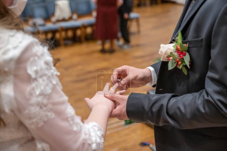 Téléchargez les photos : Alliances et les mains du couple d'échange de bague de mariée et marié lors de la cérémonie en amour. - en image libre de droit