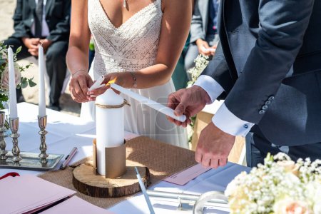 Téléchargez les photos : La bougie de mariage dans les mains de la mariée et le marié. bougie est le symbole du foyer familial à un mariage. - en image libre de droit