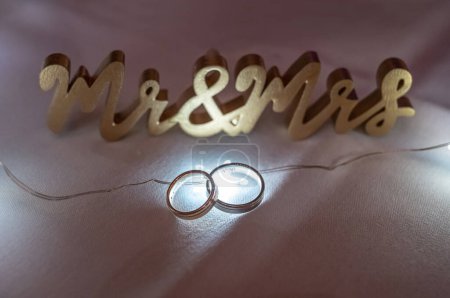 Foto de Dos anillos de boda iluminados retroiluminación con hermoso bokeh, foto de primer plano. - Imagen libre de derechos