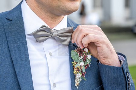 Téléchargez les photos : Boutonnière fleur marié robe de mariée manteau avec noeud papillon . - en image libre de droit