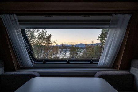 Téléchargez les photos : Coucher de soleil Saison d'automne à Abisko à travers une fenêtre caravane avec le lac Tornetraesk en arrière-plan Laponie suédoise Suède. - en image libre de droit