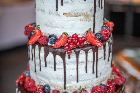 Photo for Beautiful delicious Wedding cake in many tiers with fresh wild berries and fruits. - Royalty Free Image