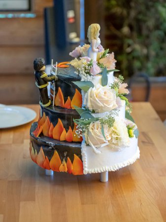 Téléchargez les photos : Deux côtés pompier beau gâteau de mariage délicieux dans beaucoup avec des fleurs sauvages fraîches sauver la fille. - en image libre de droit