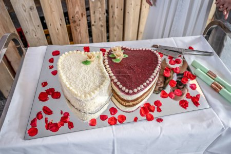Téléchargez les photos : Mariage romantique Deux gâteaux en forme de coeur, bouquet de roses sur fond de table blanche. Vue du dessus. - en image libre de droit