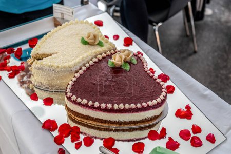 Téléchargez les photos : Mariage romantique Deux gâteaux en forme de coeur, bouquet de roses sur fond de table blanche. Vue du dessus. - en image libre de droit