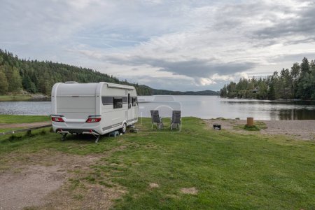 Téléchargez les photos : Camping caravane au bord du lac Ragnerudssjoen en Dalsland Suède belle forêt naturelle pinetree. - en image libre de droit