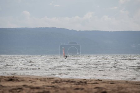 Téléchargez les photos : Melbystrand Suède Un planchiste pratique son surf près de la plage avec des dunes de sable. - en image libre de droit