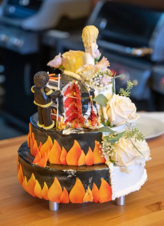 Téléchargez les photos : Deux côtés pompier beau gâteau de mariage délicieux dans beaucoup avec des fleurs sauvages fraîches sauver la fille. - en image libre de droit