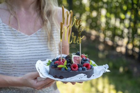 Foto de Hermosa deliciosa torta de boda con bayas silvestres frescas y frutas Mrs Ms Sign on Top. - Imagen libre de derechos