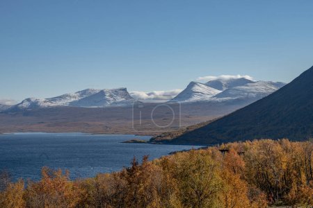 Herbstsaison in Abisko mit dem Tornetraesk-See im Hintergrund, aufgenommen aus Bjoerkliden, Schwedisch Lappland, Schweden.