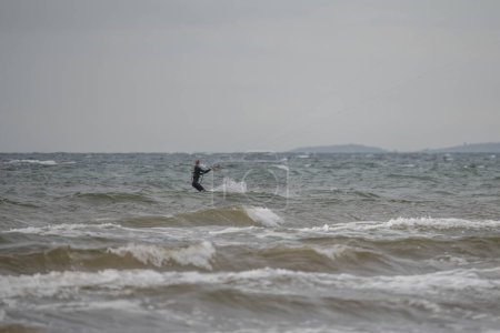 Téléchargez les photos : Melbystrand Suède Un kitesurfer pratique son surf près de la plage avec des dunes de sable. - en image libre de droit
