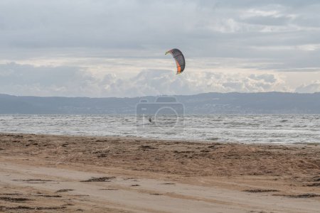 Téléchargez les photos : Melbystrand Suède Un kitesurfer pratique son surf près de la plage avec des dunes de sable. - en image libre de droit