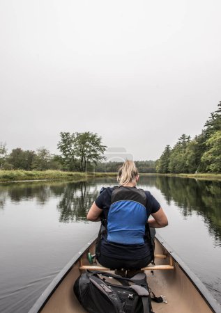 Foto de Rubia Chica en canoa paseo explorando la naturaleza en el río y las islas en la niebla de la mañana en el Parque Nacional Kejimkujik Designated Wilderness Nova Scotia Canadá - Imagen libre de derechos