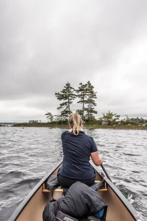 Photo for Blonde Girl on Canoe ride exploring nature on river and islands in morning mist at Kejimkujik National Park Designated Wilderness Nova Scotia Canada - Royalty Free Image