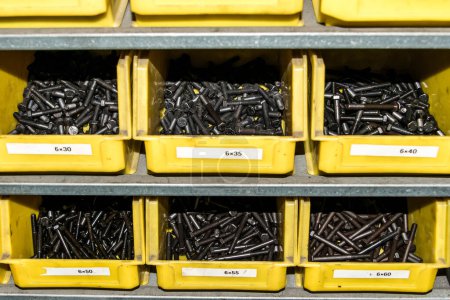 Photo for Yellow box with small construction storage compartments filled with screws, nuts, bolts workshop tools. - Royalty Free Image