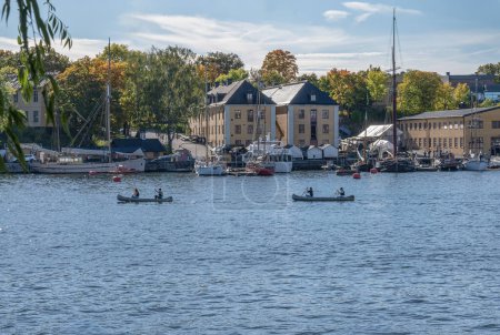 Foto de ESTOCOLMO SUECIA 26.09.2021 Hombre y mujer reman una canoa en Estocolmo entre las islas. - Imagen libre de derechos