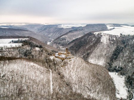 Photo for Aerial view rock with medieval castle Ehrenburg on it near moselle river in Brodenbach with white winter snow wonderland forest hills - Royalty Free Image