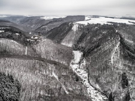 Téléchargez les photos : Vue aérienne rocher avec château médiéval Ehrenburg sur elle près de la rivière de la moselle à Brodenbach avec neige blanche hiver merveilleux collines forestières - en image libre de droit