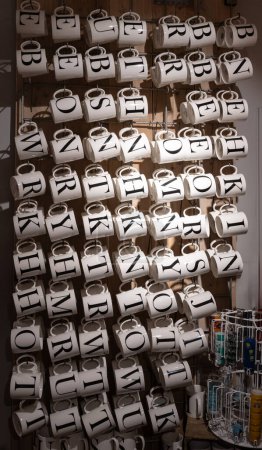 Foto de Tiro de tazas de cerámica en una tienda con letra negra del alfabeto de la impresión en él para el nombre. - Imagen libre de derechos