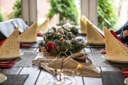 Foto de Decoración festiva de la mesa de cena para Navidad con papel, luces. - Imagen libre de derechos