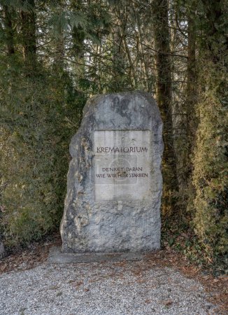 Foto de Dachau Concentration Camp Memorial Site. Monumento a las víctimas. El letrero fuera del edificio Crematorio dice en alemán: Piensa en cómo morimos aquí - Imagen libre de derechos