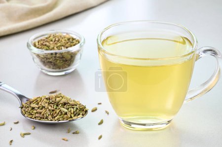 Téléchargez les photos : Fennel seed water in a glass cup with fennel seeds in the background - en image libre de droit