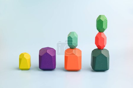 Concept of growth. Multicolored wooden blocks arranged on a blue background