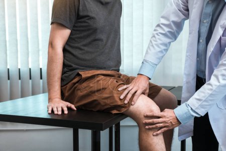 Téléchargez les photos : Les physiothérapeutes asiatiques vérifient les genoux des patients. - en image libre de droit