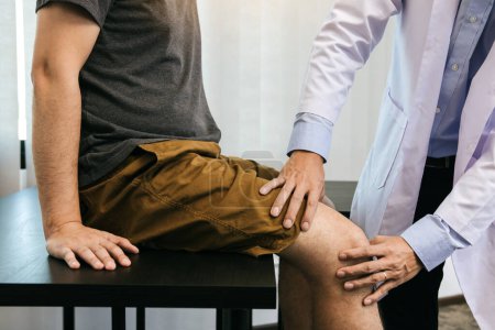 Téléchargez les photos : Les physiothérapeutes asiatiques vérifient les genoux des patients. - en image libre de droit