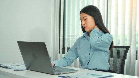 Téléchargez les photos : Jeune femme asiatique est assis dans un bureau d'entreprise et a la douleur dans son cou. - en image libre de droit