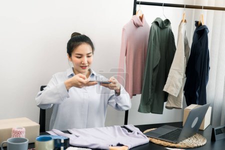 Téléchargez les photos : Entrepreneurs asiatiques bavarder avec les clients et prendre des photos de leurs produits envoyés au choix d'une collection. - en image libre de droit