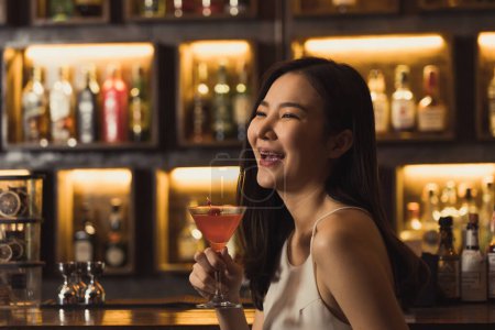 Téléchargez les photos : Femmes asiatiques buvant des cocktails et s'amusant au bar la nuit. - en image libre de droit