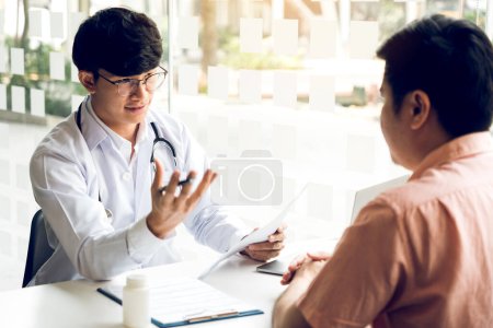Téléchargez les photos : Le médecin explique le traitement de la maladie du patient au bureau. - en image libre de droit