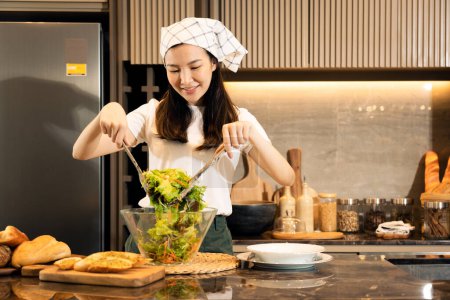 Téléchargez les photos : Asiatique ménagère préparer des légumes frais pour faire de la salade à la maison comptoir de cuisine. - en image libre de droit
