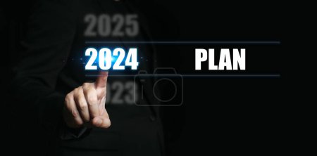 Téléchargez les photos : Nouvel an 2024 avec des plans. Homme d'affaires indiquant les chiffres de l'année pour fixer des objectifs et faire des plans pour l'année à venir. - en image libre de droit