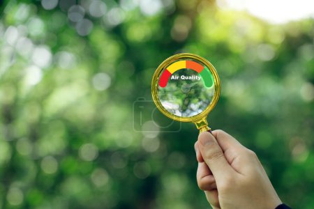 Photo for Hand holding a magnifying glass to check the good air quality and clean outdoor air quality safe. - Royalty Free Image