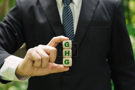 Foto de Concepto de negocio y GEI, símbolo de gases de efecto invernadero Empresario sosteniendo un cubo. - Imagen libre de derechos