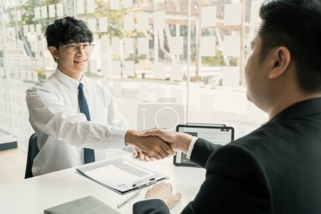 Téléchargez les photos : Concept d'entrevue du gestionnaire et de l'employé avec poignée de main après avoir parlé de signature de contrat. - en image libre de droit