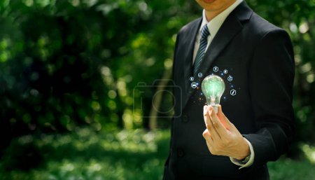 Man holding light bulb environment with  that represents green energy Renewable and clean energy.