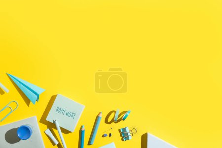 Yellow background and blue school supplies.   Back to school. Flat lay.