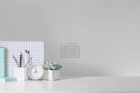 Photo for Desk at home office with supplies and wall copy space. Minimalistic workspace. - Royalty Free Image