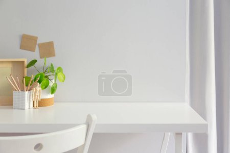 Téléchargez les photos : Bureau à domicile avec fournitures et espace de copie murale. Espace de travail minimaliste. - en image libre de droit
