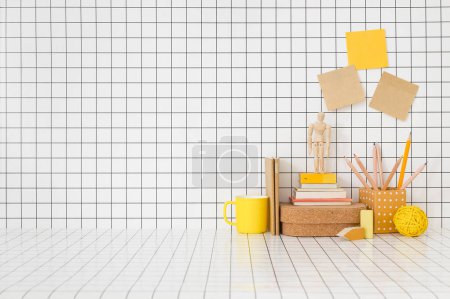 Photo for Creative desk. Table with wooden and yellow, supplies and checkered wall. - Royalty Free Image