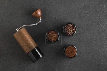 Photo for Manual Coffee grinder and jars of freshly ground coffee from roasted beans on wooden rustic table. Top view. - Royalty Free Image