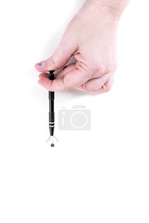 Téléchargez les photos : Main humaine saisissant une perle avec un outil de préhension de fil - en image libre de droit