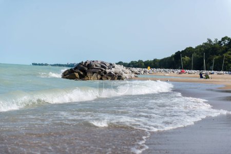 Chicago, IL, Estados Unidos - Augus 27, 2023: Beach near Lake Michigan. Un montón de piedras grandes cerca del lago y la playa. La gente se relaja en la playa.