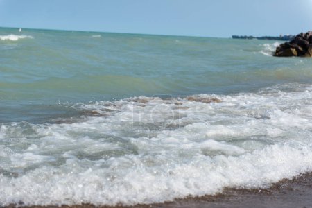 Plage près du lac Michigan. Des vagues violentes. Un tas de grosses pierres près du lac et de la plage.  
