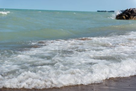Plage près du lac Michigan. Des vagues violentes. Un tas de grosses pierres près du lac et de la plage.  